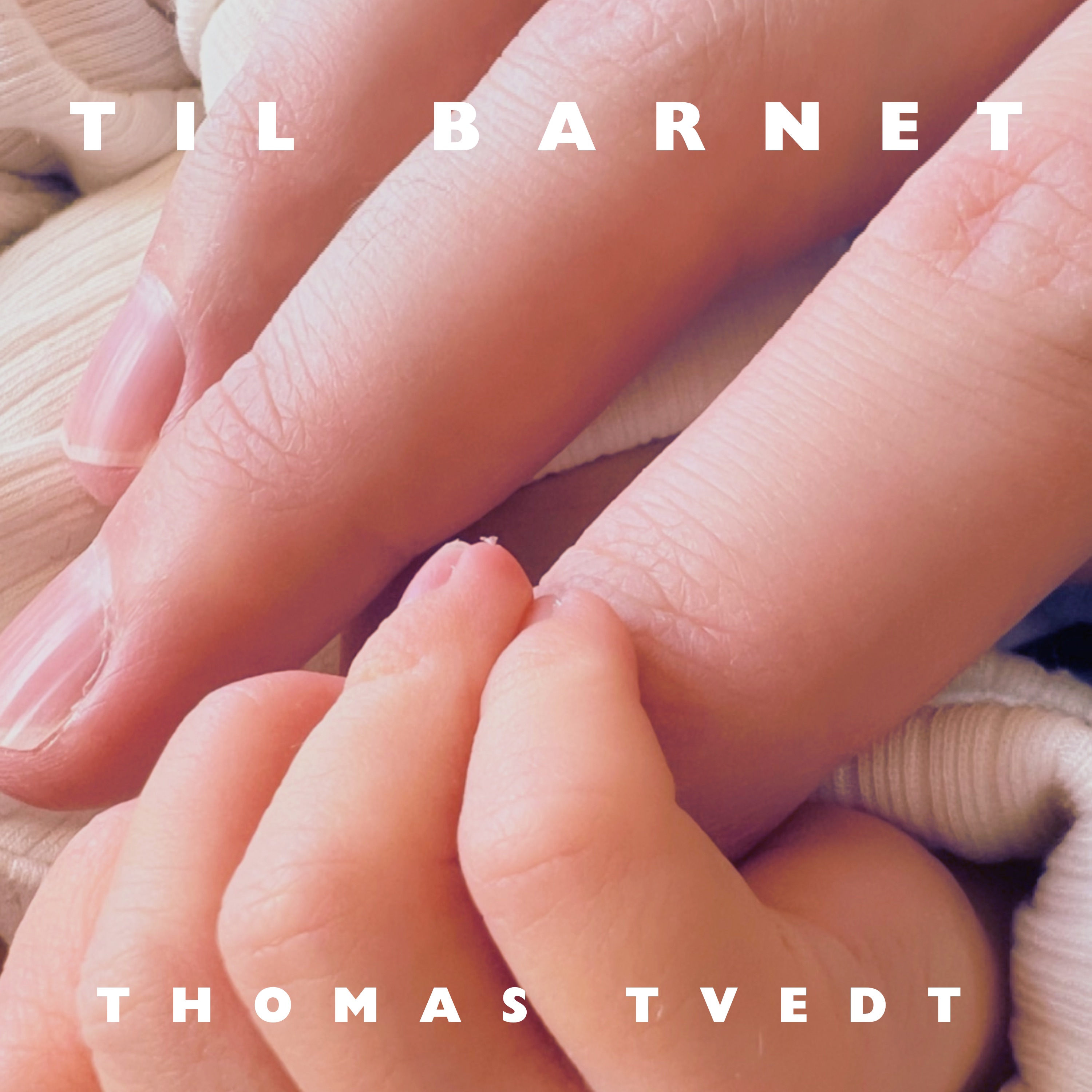 Cover for «Til barnet»: en voksen hånd og en nyfødt babyhånd som holder rundt hverandre, mot mykt lyst stoff.